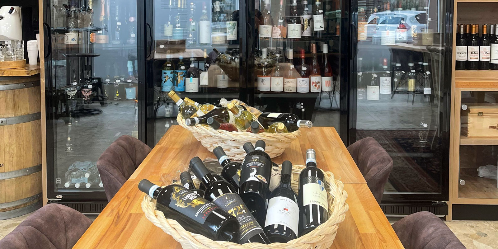 Zahlreiche Flaschen Weiß- und Rotwein liegen in zwei Bastkörben